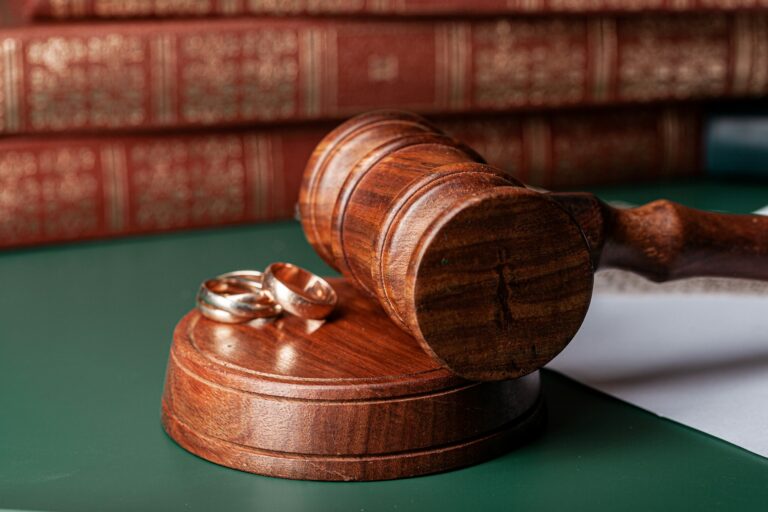 Law gavel and wedding rings on table